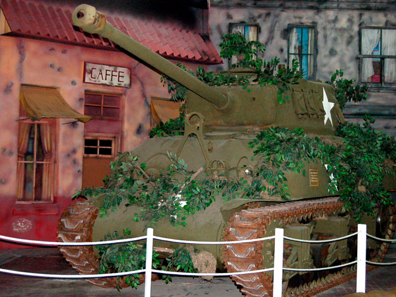 A museum exhibit inside Fort Bliss and Old Ironsides Museums featuring a replica US Army tank and a prop cafe.